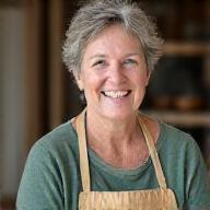 Elena, a potter from New Mexico, smiling at her wheel